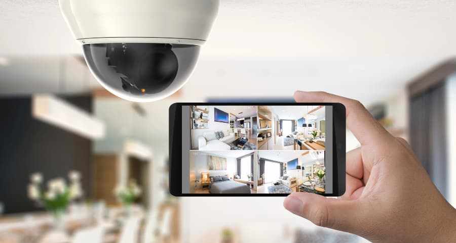 Homeowner holding smartphone with video feed from security cameras in Sacramento