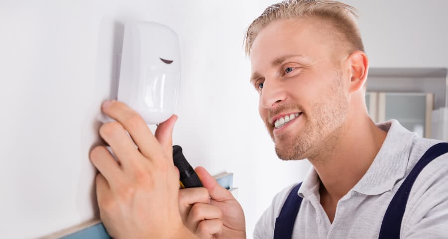 Man connecting a motion sensor on a wall